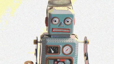 A tiny teal metal robot with round eyes and a rectangular mouth
