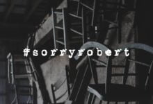 Wooden chairs with text reading "#sorryrobert"